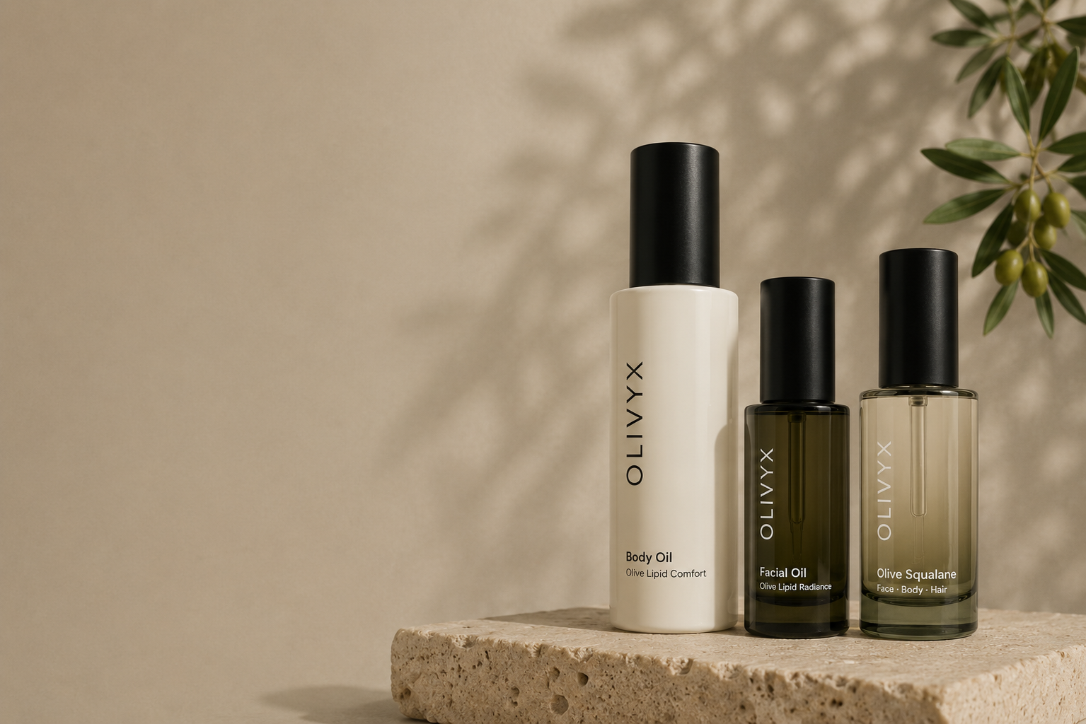Tres productos OLIVYX sobre piedra con una rama de olivo